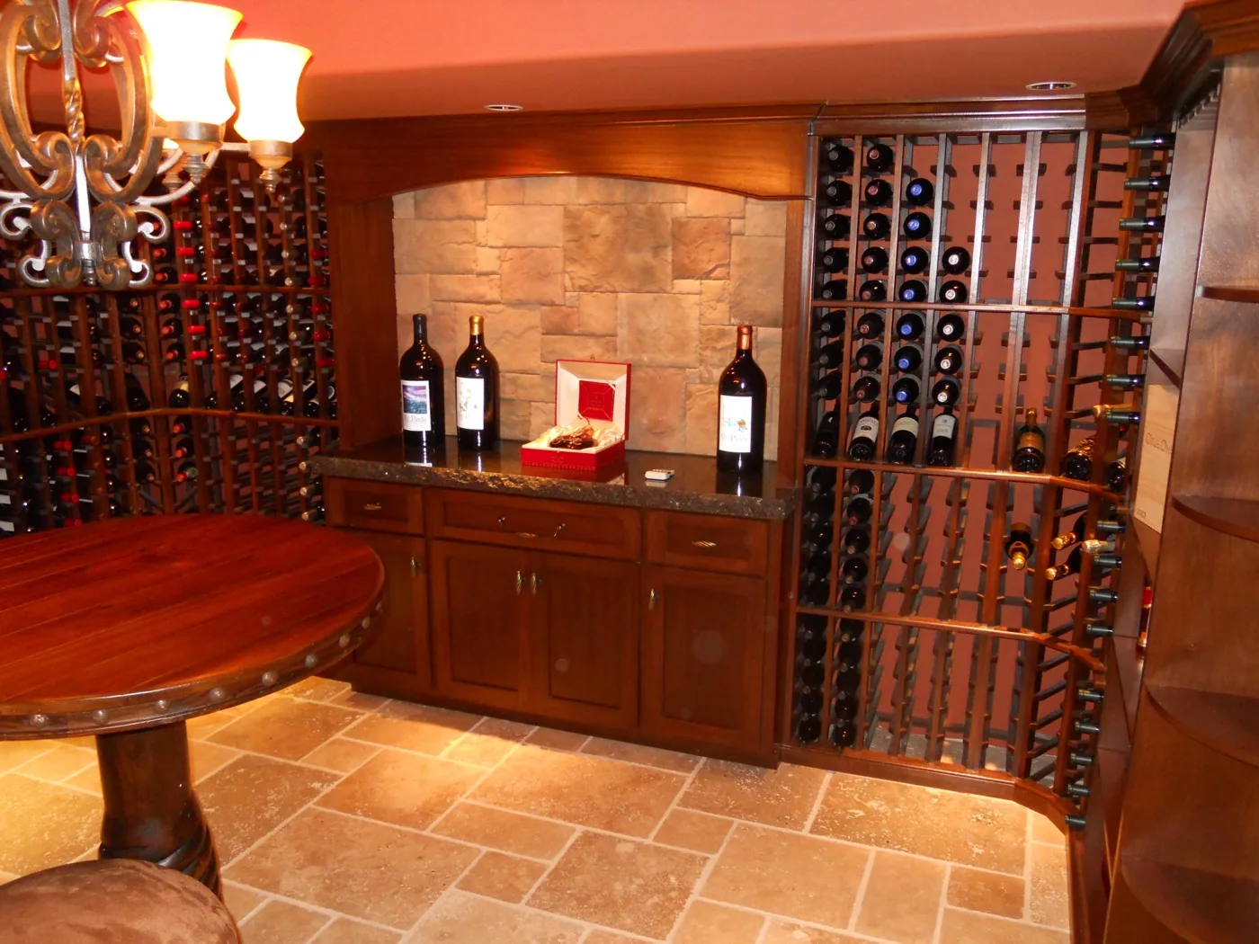 A black bar counter with lit glass shelving above the back bar